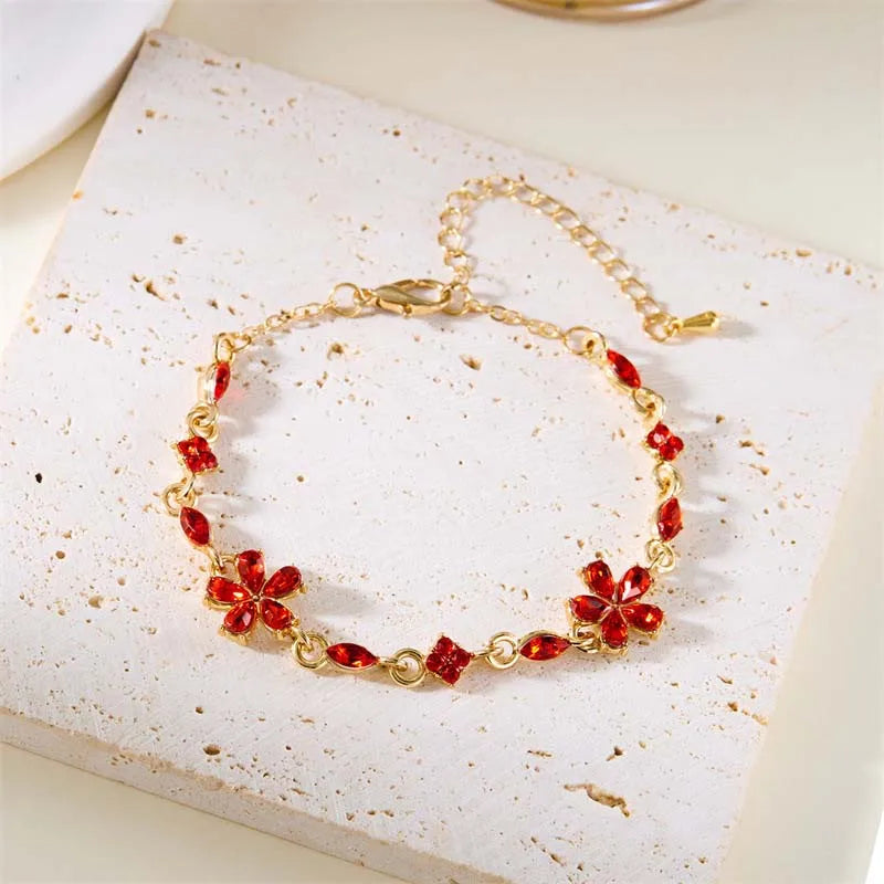 Bracelet doré avec cristaux et fleurs rouges