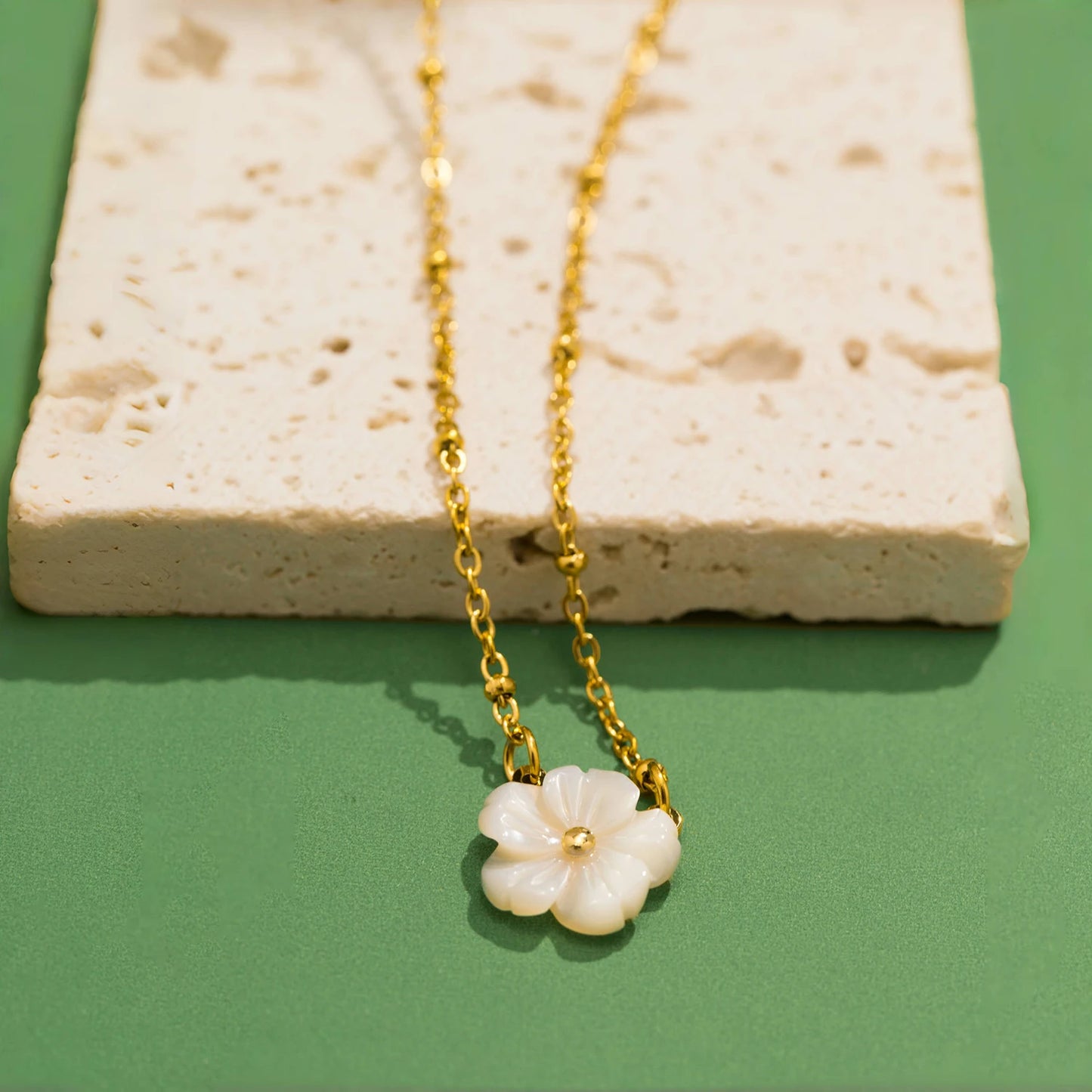 Collier doré avec fleur blanche