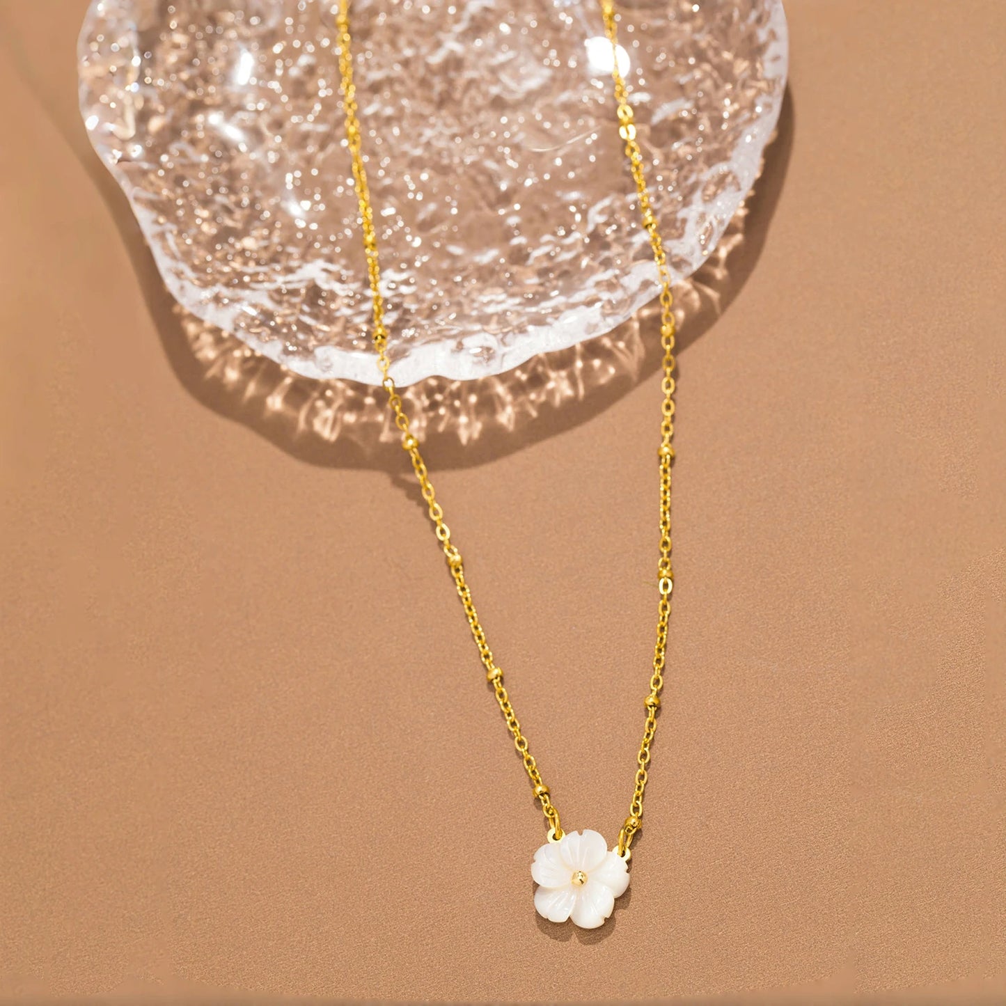 Collier doré avec fleur blanche