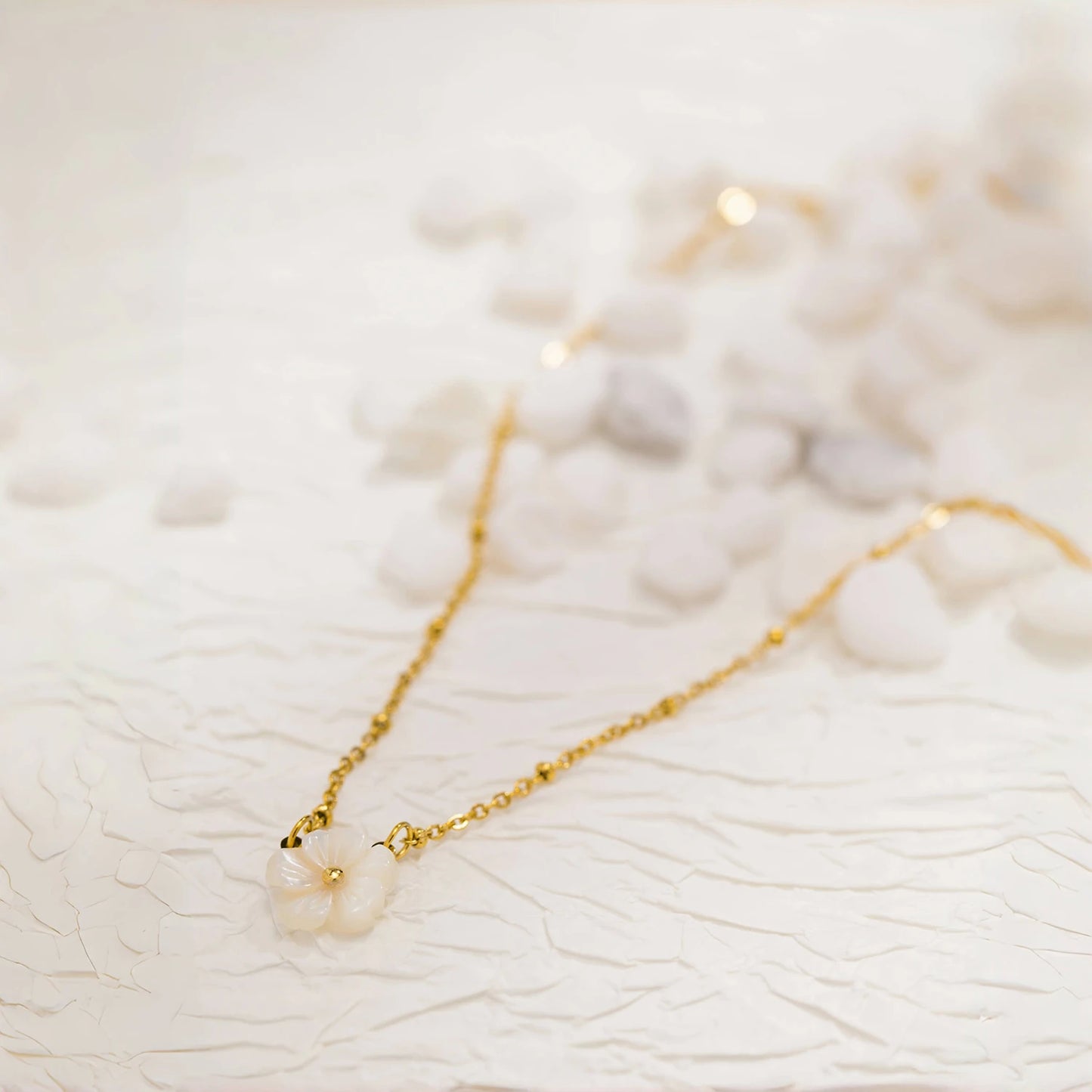 Collier doré avec fleur blanche