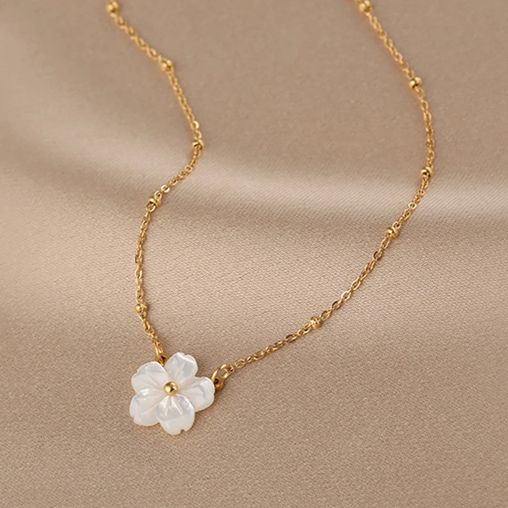 Collier doré avec fleur blanche